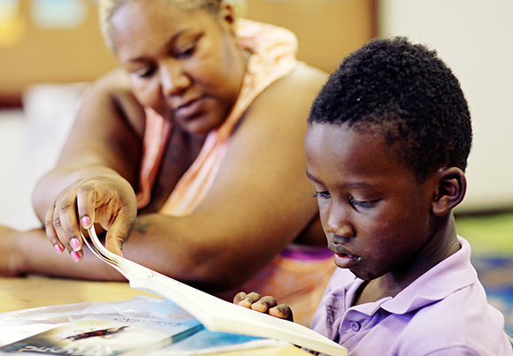 Kalan Hall and his mother read a book.