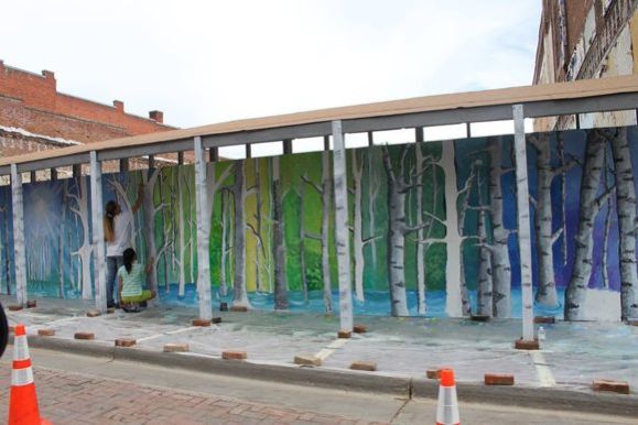 Artists work on a treescape in Trinidad